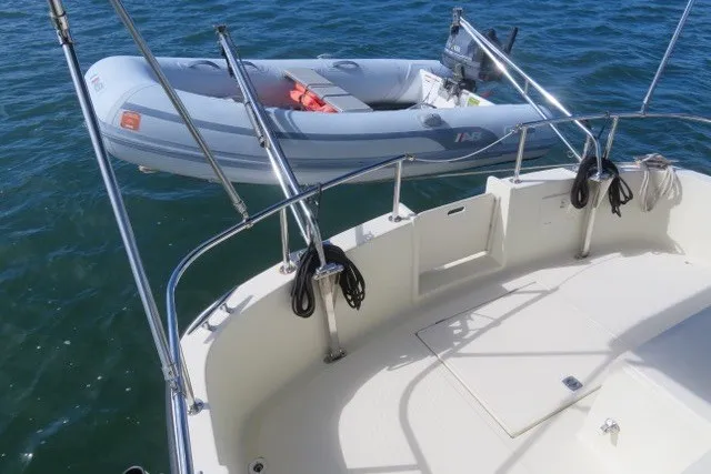 Slide: The Image of Nordic Tug 32 (2001) deck with dinghy on calm water. - 8