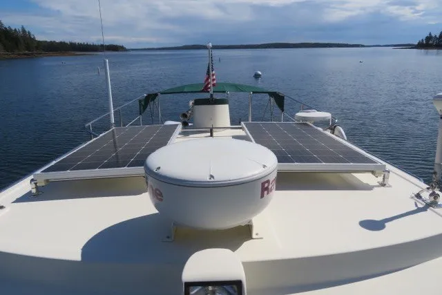 Slide: The Image of 2001 Nordic Tug 32 with solar panels on deck, cruising in calm waters. - 14