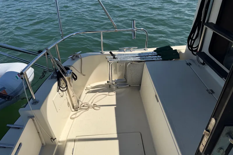 Slide: The Image of Nordic Tug 32 (2001) boat deck with railing, ladder, and calm water view. - 6