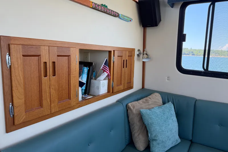 Slide: The Image of Cozy interior of 2001 Nordic Tug 32 with wooden cabinets and blue seating. - 29