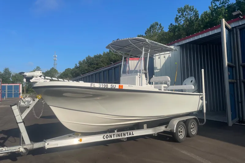 The Image of 2021 Dusky 227 Open Fisherman boat on trailer, parked outdoors near storage units. - 0