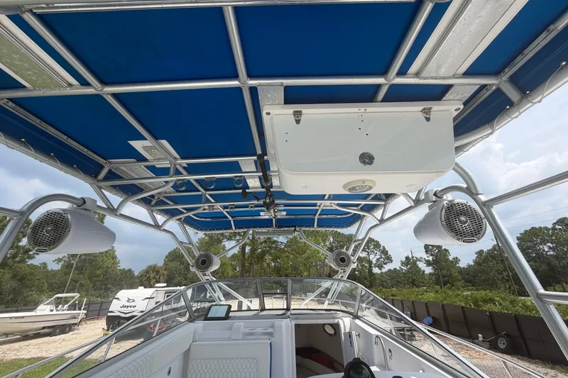 Slide: The Image of 2000 Pro-Line 32 Express boat interior with blue canopy and mounted speakers. - 25