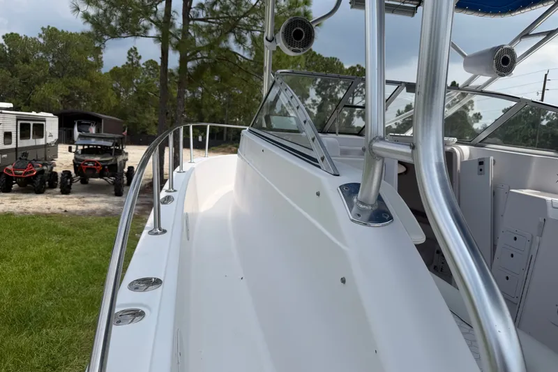 Slide: The Image of 2000 Pro-Line 32 Express boat with sleek design, parked near off-road vehicles and trailers. - 26