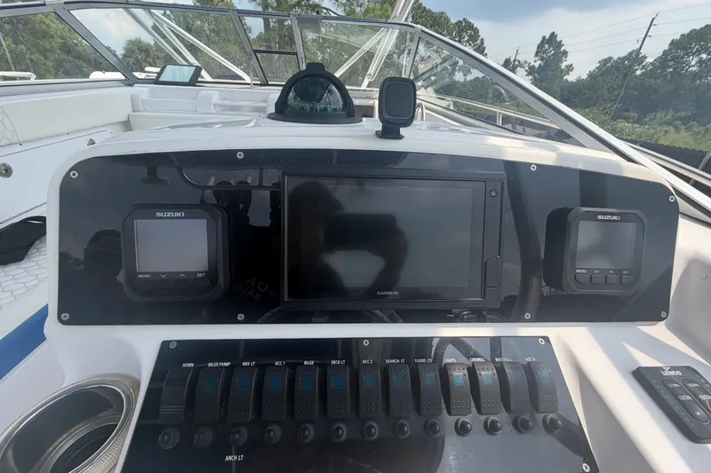 Slide: The Image of Control panel of a 2000 Pro-Line 32 Express boat with Suzuki displays and Garmin navigation. - 18
