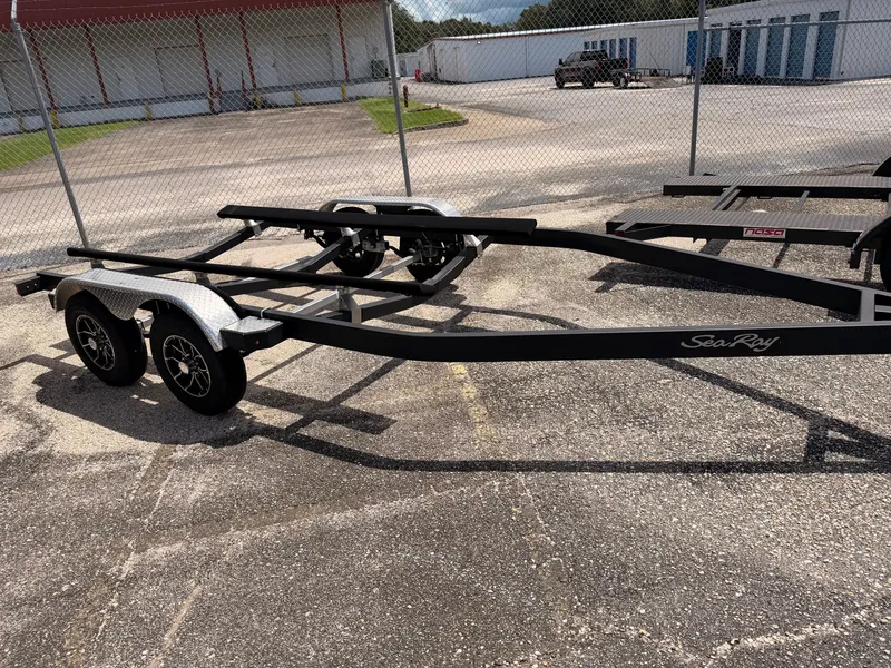 Slide: The Image of A Sea Ray boat trailer is parked on a paved lot, surrounded by a fence. - 44