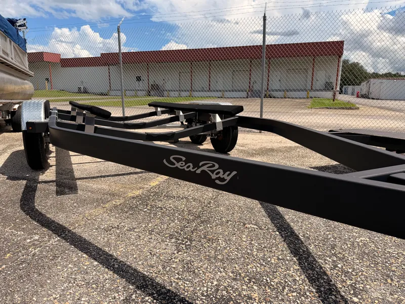 Slide: The Image of A Sea Ray boat trailer is parked on a lot in front of a building with a red roof. - 41