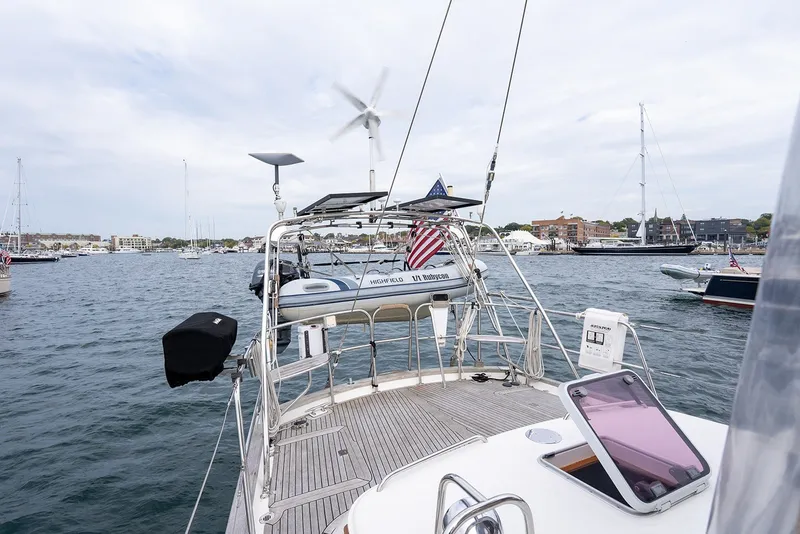 Slide: The Image of 2008 Passport Vista 515 Center Cockpit yacht in a bustling marina, featuring a dinghy and wind turbine. - 40