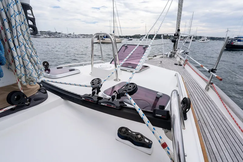 Slide: The Image of 2008 Passport Vista 515 Center Cockpit sailboat deck with ropes and winches in a marina. - 38