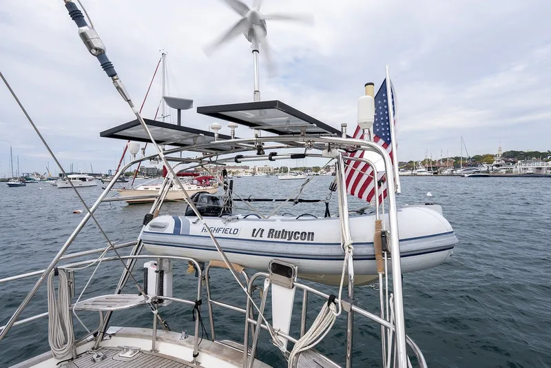 Slide: The Image of Sailboat "Passport Vista 515 Center Cockpit" with dinghy and American flag in harbor, 2008 model. - 41