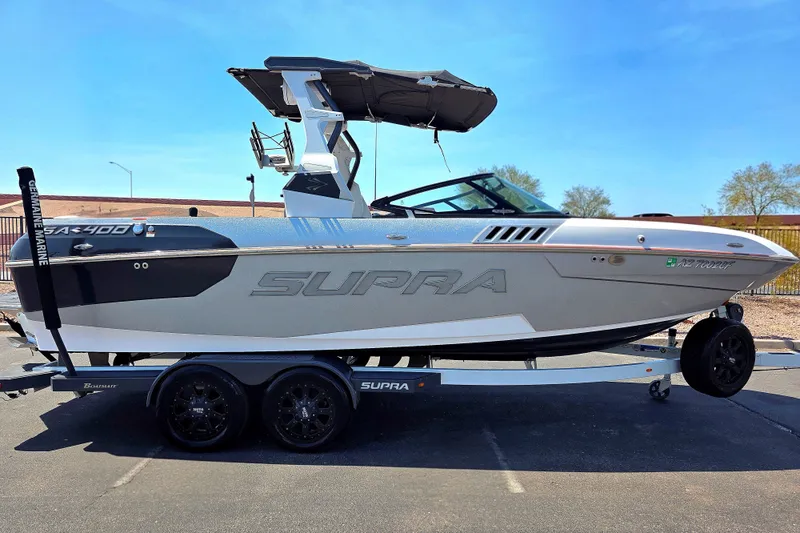 Slide: The Image of 2018 Supra SA 400 boat on trailer, sleek design, parked outdoors under clear blue sky. - 7