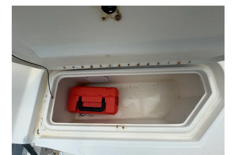 Slide: The Image of Storage compartment of a 1999 Hydra-Sports 20 Bay Sport boat with a red toolbox inside. - 33