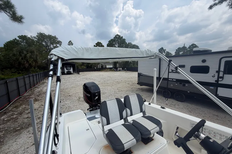 Slide: The Image of 1999 Hydra-Sports 20 Bay Sport boat with bimini top and dual seats, parked near RV. - 37