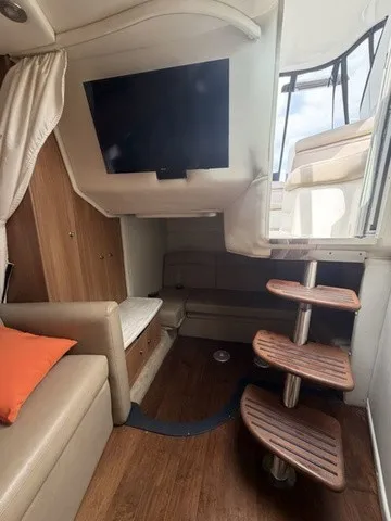 Slide: The Image of Interior of the Rinker 360 Express Cruiser with sofa, TV, and wooden steps. - 15