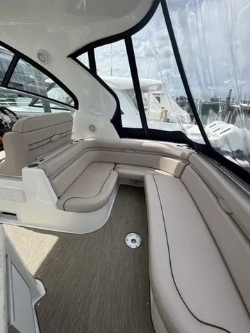 Slide: The Image of Interior of a 2015 Rinker 360 Express Cruiser with beige seating and large windows. - 5