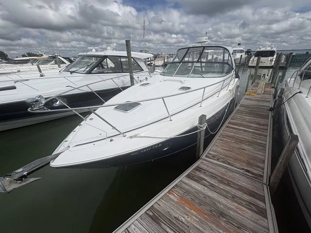 Slide: The Image of A 2015 Rinker 360 Express Cruiser docked at a wooden pier in a marina. - 2