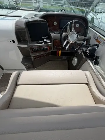 Slide: The Image of The cockpit of the 2015 Rinker 360 Express Cruiser features a modern helm with leather seating. - 8