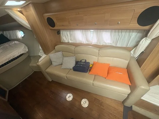 Slide: The Image of Interior of the 2015 Rinker 360 Express Cruiser with beige sofa and wooden floor. - 17