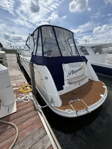 Slide: The Image of 2015 Rinker 360 Express Cruiser at dock with blue cover and wooden deck. - 3