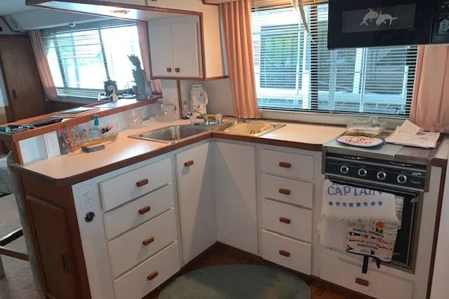 Slide: The Image of 1993 Harbor Master 450 Coastal Cruiser kitchen with white cabinets and nautical decor. - 32