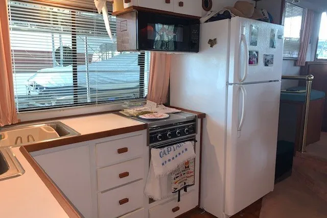 Slide: The Image of Kitchen area of a 1993 Harbor Master 450 Coastal Cruiser with appliances and cabinetry. - 33