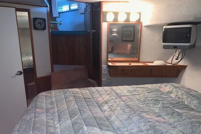 Slide: The Image of Interior of 1993 Harbor Master 450 Coastal Cruiser with bed, mirror, and TV. - 24