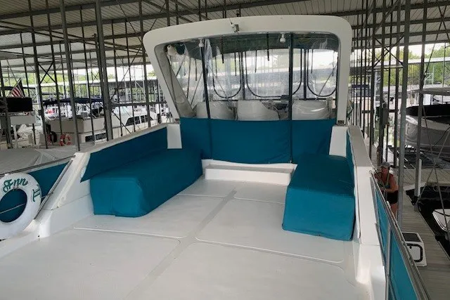 Slide: The Image of 1993 Harbor Master 450 Coastal Cruiser with teal seating in a covered marina. - 16