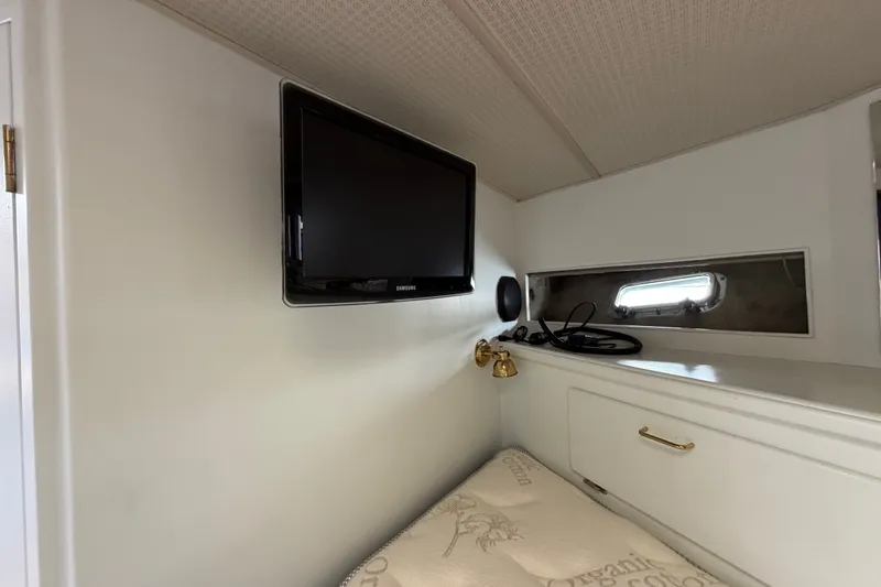 Slide: The Image of 1988 Tollycraft 44 Cockpit Motor Yacht interior with TV and porthole window. - 34