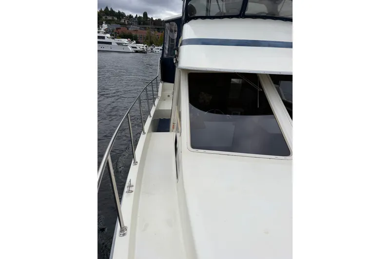 Slide: The Image of 1988 Tollycraft 44 Cockpit Motor Yacht docked, side view with railing and windows. - 10