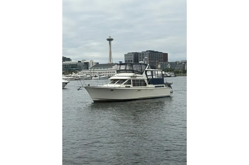 Slide: The Image of 1988 Tollycraft 44 Cockpit Motor Yacht on water with cityscape and tower in background. - 5
