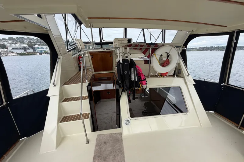 Slide: The Image of 1988 Tollycraft 44 Cockpit Motor Yacht interior with stairs, life ring, and waterfront view. - 14