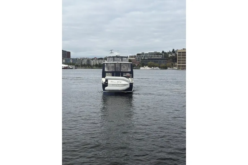 Slide: The Image of 1988 Tollycraft 44 Cockpit Motor Yacht on calm water, urban skyline background. - 3