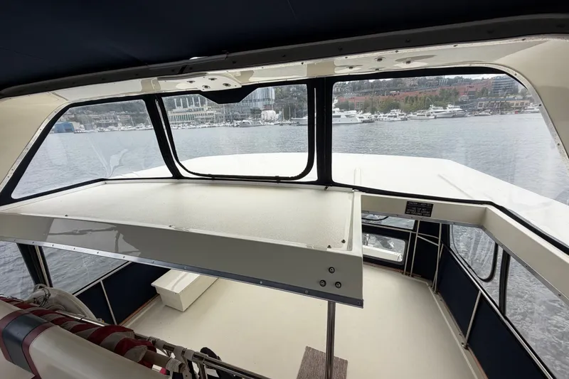 Slide: The Image of 1988 Tollycraft 44 Cockpit Motor Yacht interior with marina view through windows. - 16