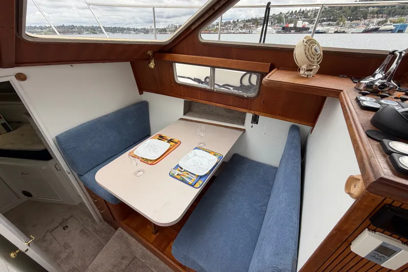 Slide: The Image of 1988 Tollycraft 44 Cockpit Motor Yacht interior with dining area and scenic window view. - 30