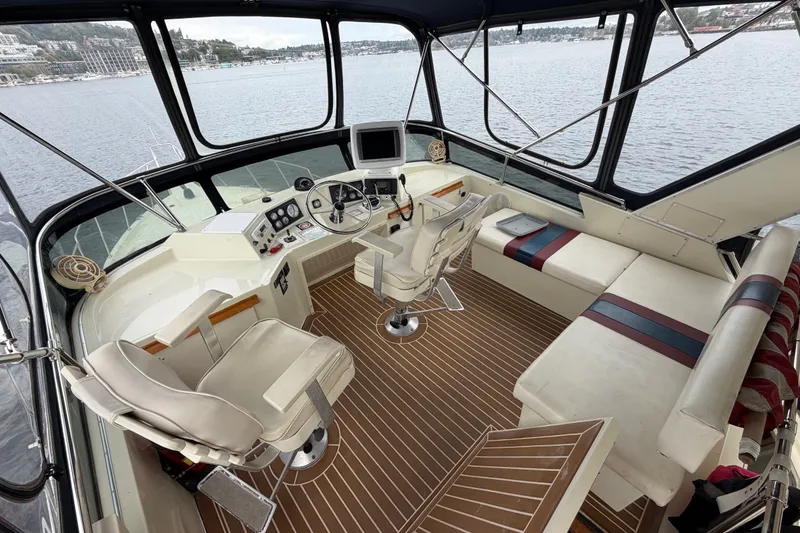 Slide: The Image of 1988 Tollycraft 44 Cockpit Motor Yacht interior with helm, seating, and panoramic water view. - 15