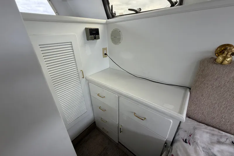 Slide: The Image of 1988 Tollycraft 44 Cockpit Motor Yacht interior with white cabinetry and gold accents. - 39