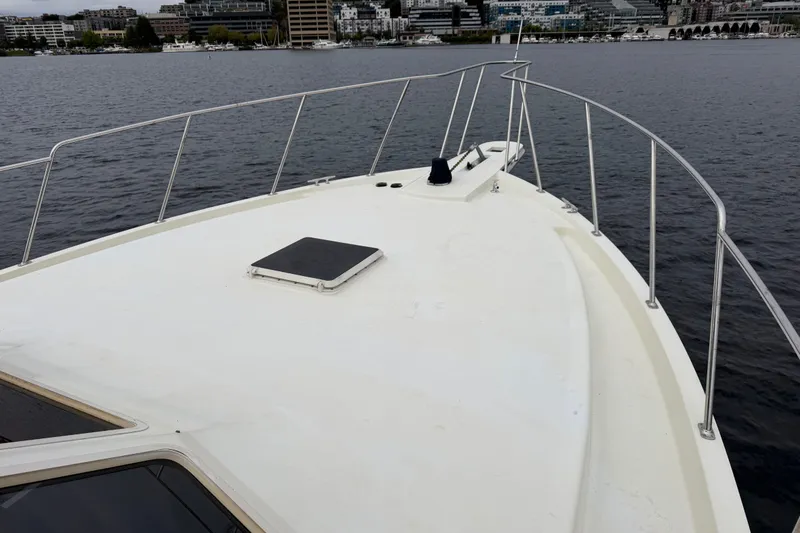 Slide: The Image of 1988 Tollycraft 44 Cockpit Motor Yacht bow view on calm water, cityscape background. - 6