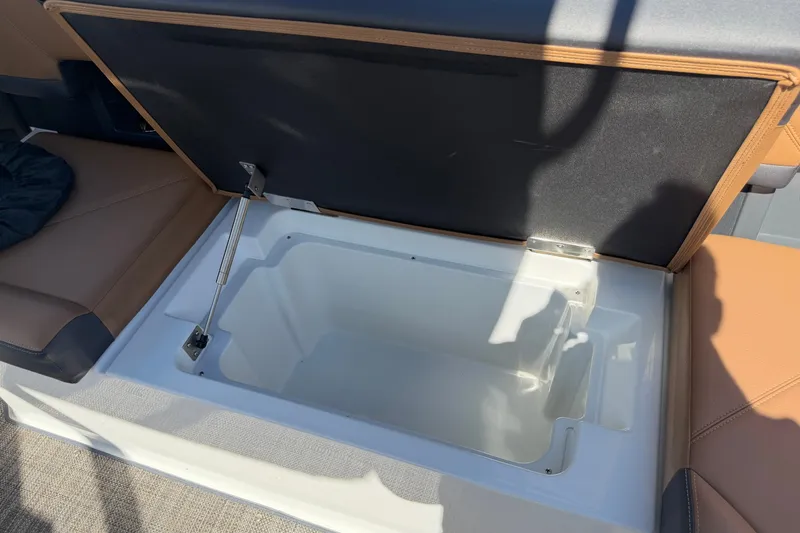 Slide: The Image of Open storage compartment in 2025 Cobalt R8 Outboard boat with cushioned seating. - 20