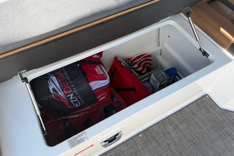 Slide: The Image of Storage compartment in 2025 Cobalt R8 Outboard boat with various items and accessories. - 21