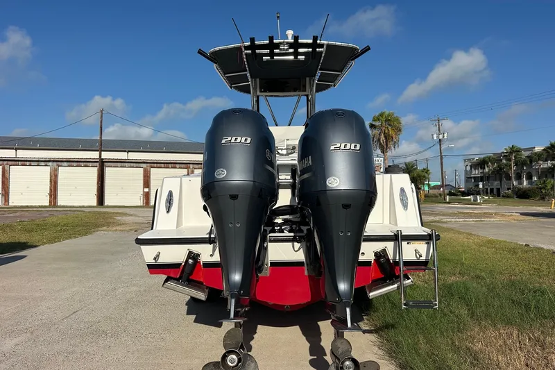 Slide: The Image of 2005 Contender 23 Tournament boat with dual Yamaha 200 engines, parked outdoors. - 2