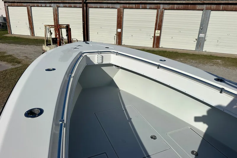 Slide: The Image of 2005 Contender 23 Tournament boat deck with storage compartments, parked near storage units. - 7