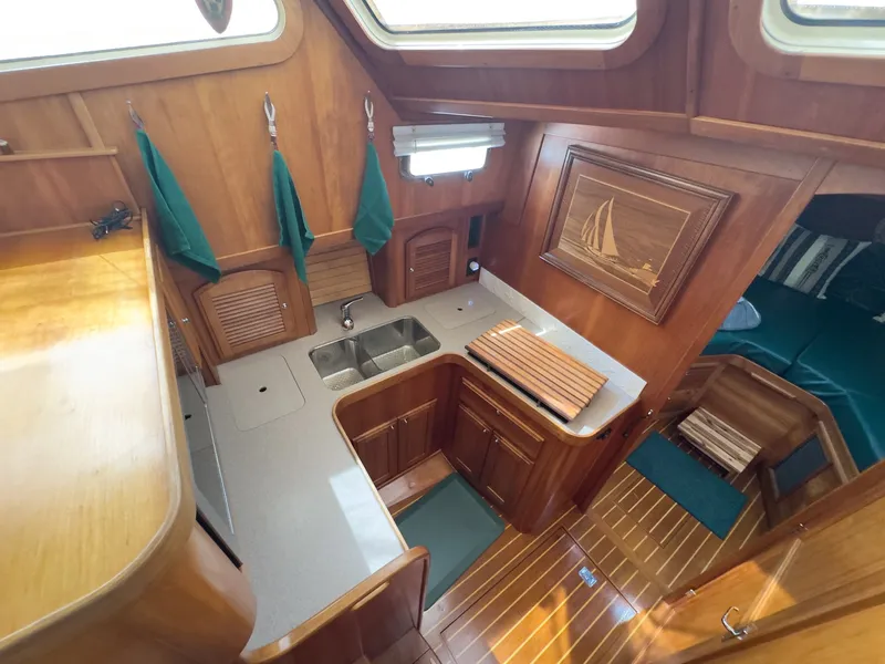Slide: The Image of The 2002 Sabre 36 Express galley features wood paneling, a sink, and ample storage space. - 19