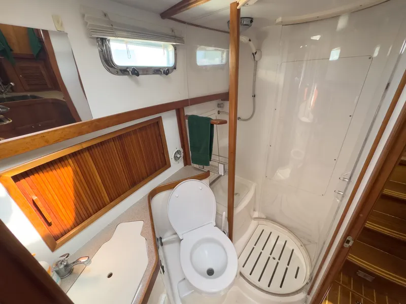 Slide: The Image of The image shows a boat bathroom with a toilet, sink, and shower. - 27