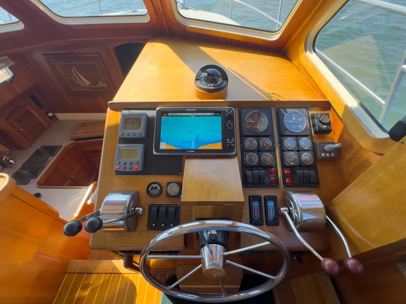 Slide: The Image of The cockpit of a 2002 Sabre 36 Express with wood paneling and modern instruments. - 12