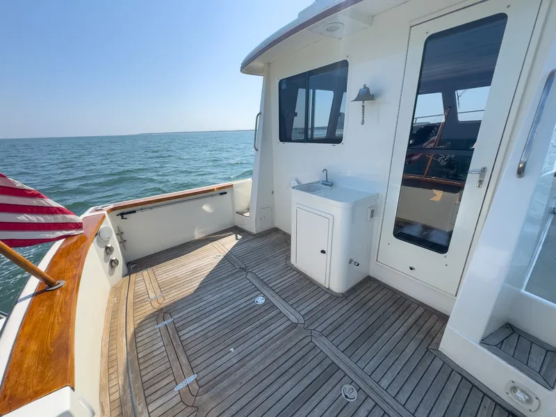 Slide: The Image of The 2002 Sabre 36 Express features a sleek deck with teak flooring and a small sink. - 33
