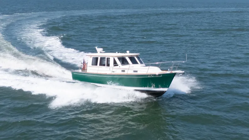 Slide: The Image of A green 2002 Sabre 36 Express boat speeds across the water. - 2