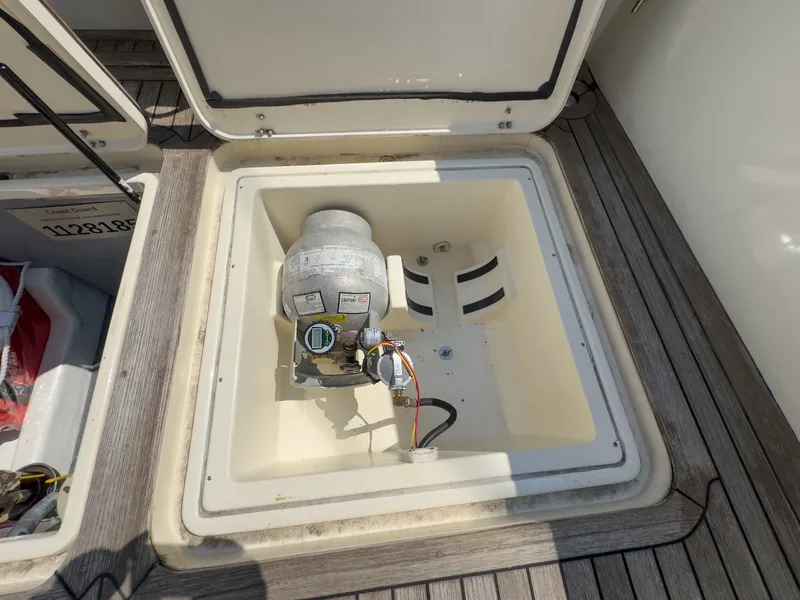 Slide: The Image of An open storage compartment on a 2002 Sabre 36 Express boat with a device inside. - 45