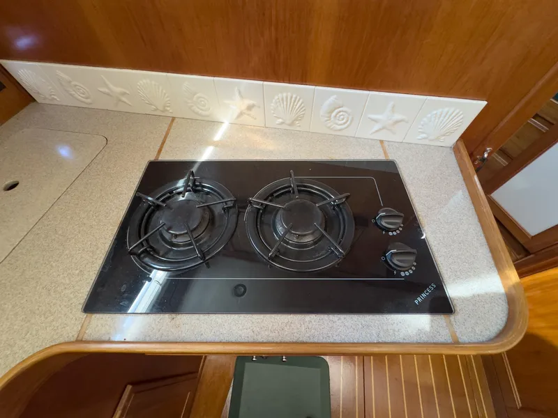 Slide: The Image of The 2002 Sabre 36 Express galley features a modern two-burner cooktop. - 23