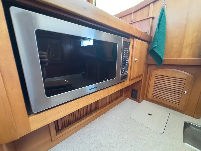 Slide: The Image of The galley of a 2002 Sabre 36 Express with a microwave and wood paneling. - 22