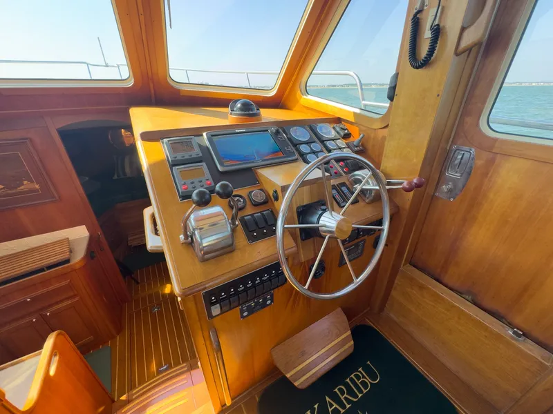 Slide: The Image of The cockpit of a 2002 Sabre 36 Express with wood paneling and modern navigation instruments. - 11