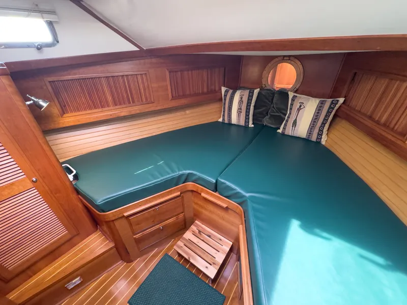 Slide: The Image of The cabin of a 2002 Sabre 36 Express with green cushions and wood paneling. - 25
